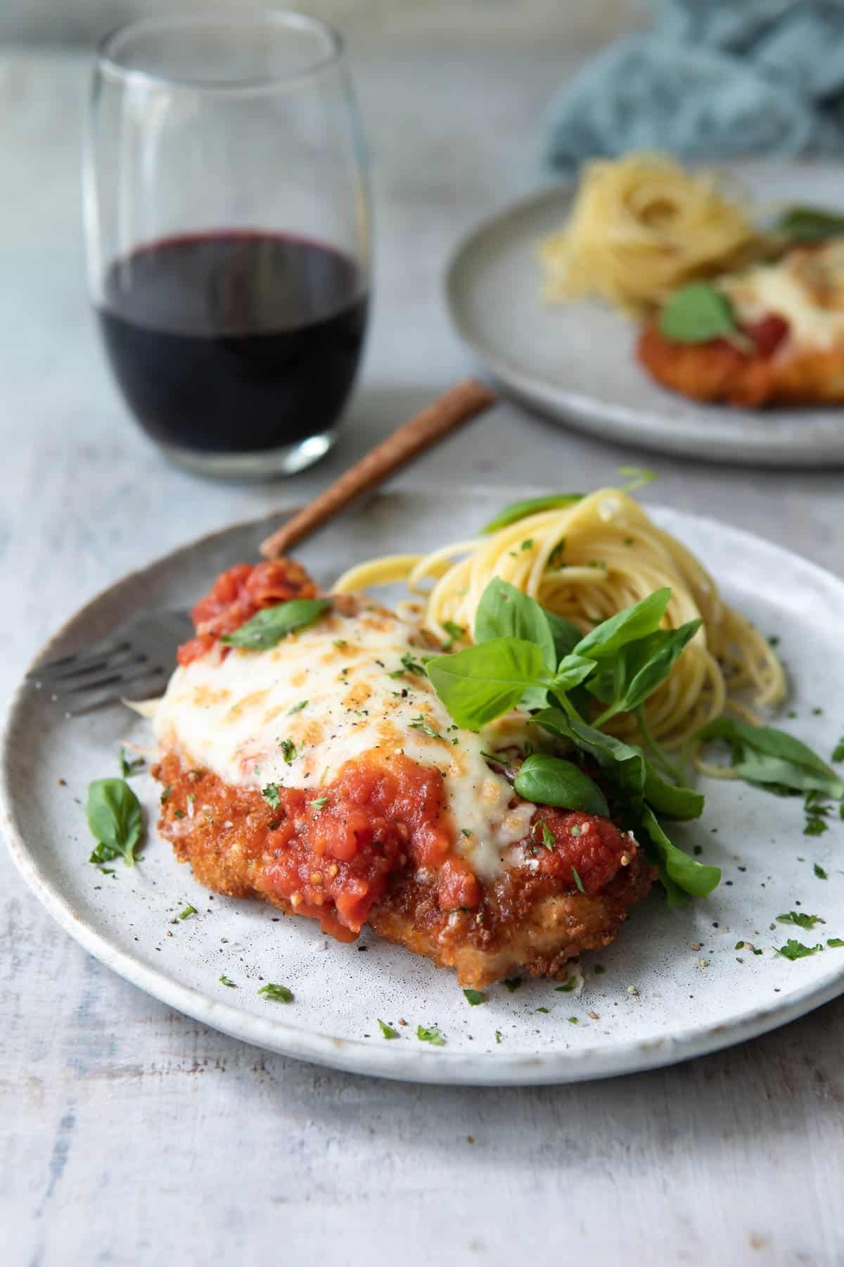 Chicken Parmesan plated with spaghetti.