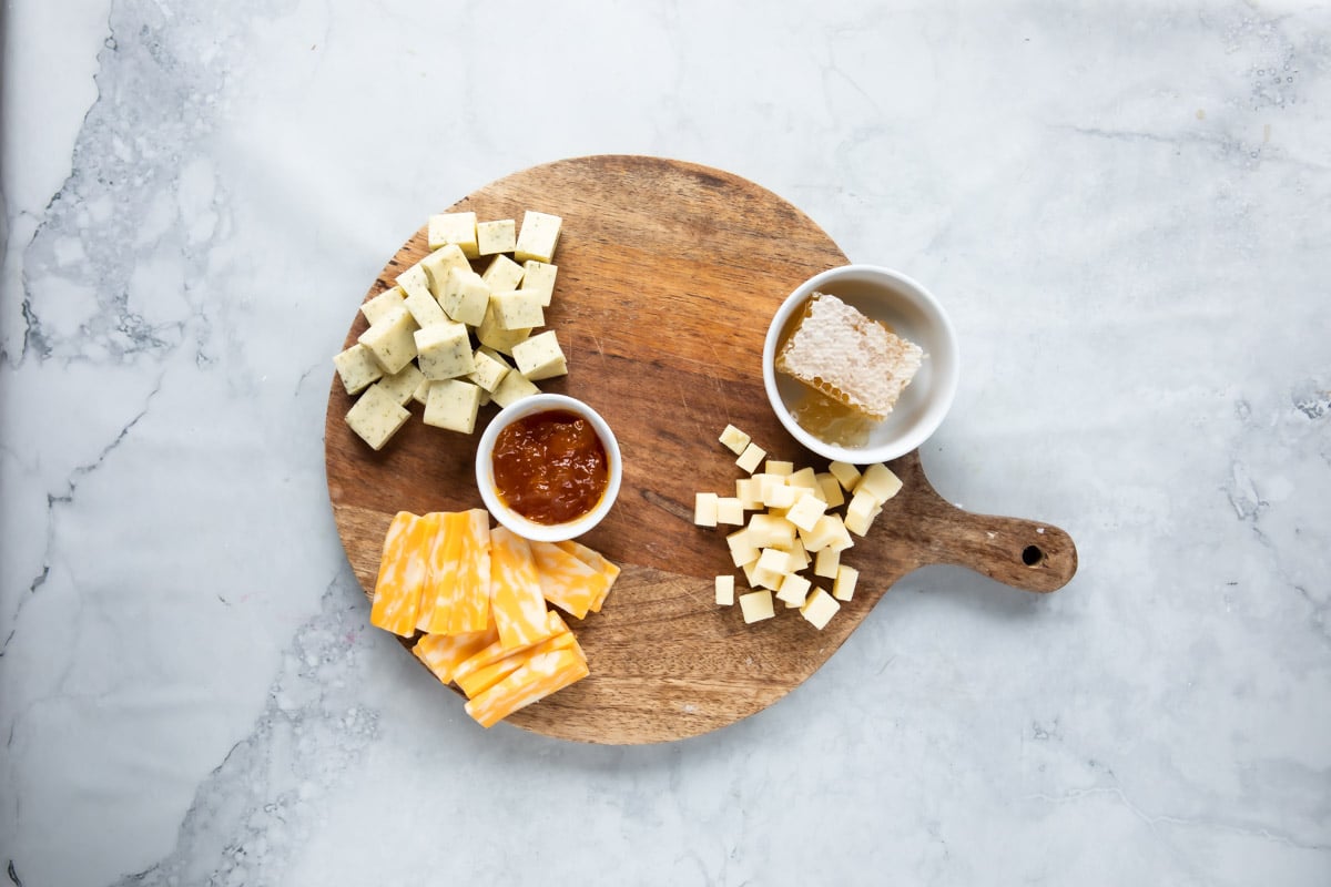 Cheese and jam on a wooden board.