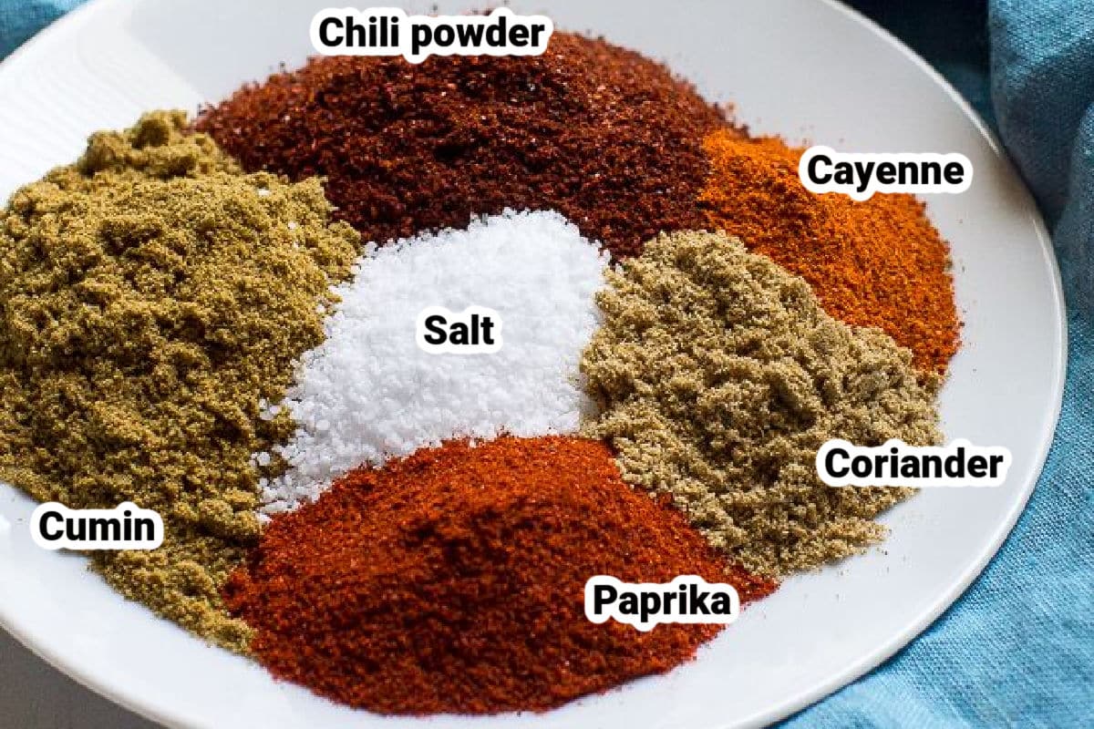 Labeled taco seasoning ingredients on a white plate.