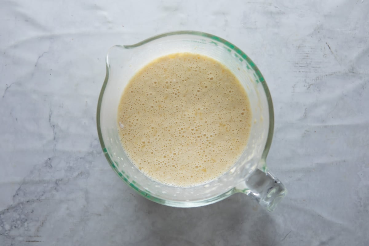 Popover batter in a glass measuring cup.