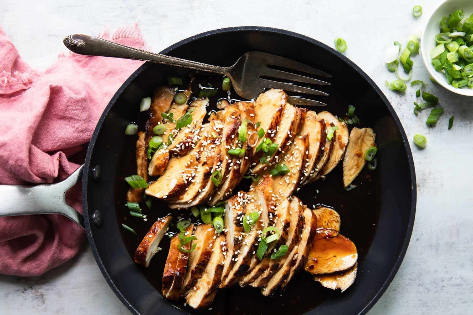 A skillet full of Teriyaki chicken.