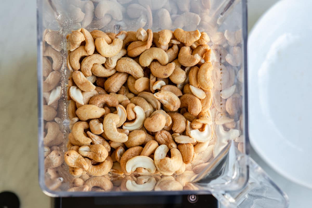 Blending cashews in a blender to make cashew butter.
