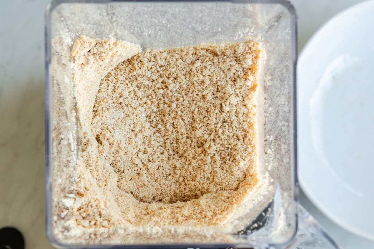 Blending cashews in a blender to make cashew butter.