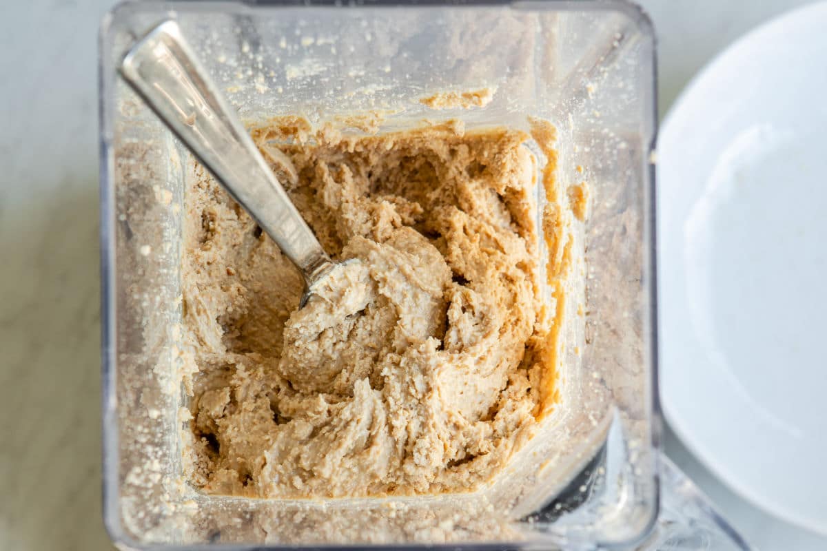 Blending cashews in a blender to make cashew butter.
