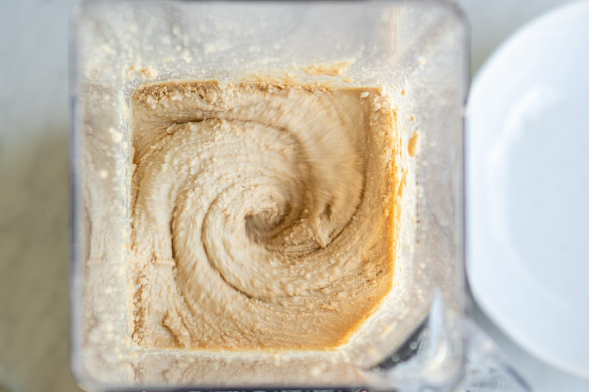 Blending cashews in a blender to make cashew butter.