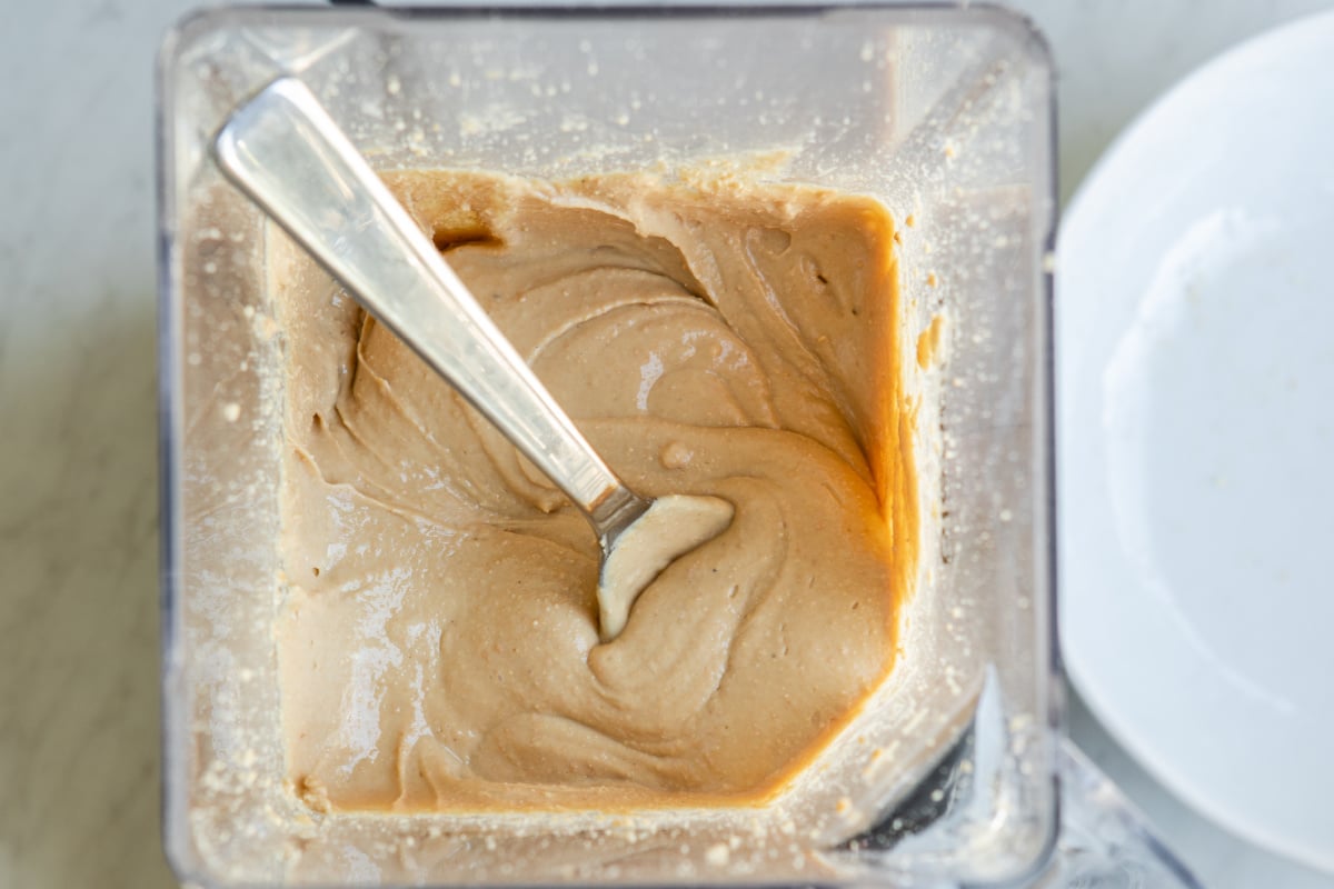 Blending cashews in a blender to make cashew butter.