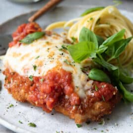 Chicken Parmesan plated with spaghetti.