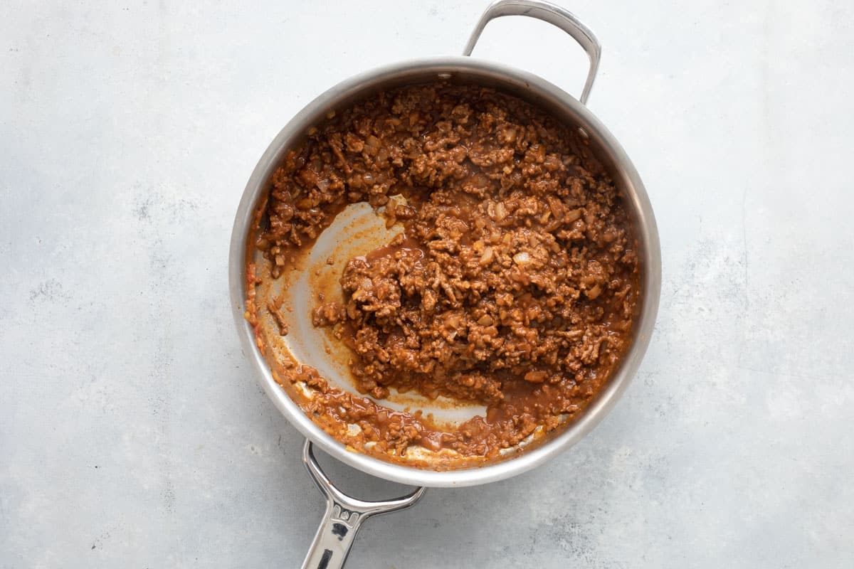 Cooking ground meat for beef tacos in a skillet.