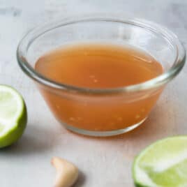 A clear glass bowl of Nuoc Cham.