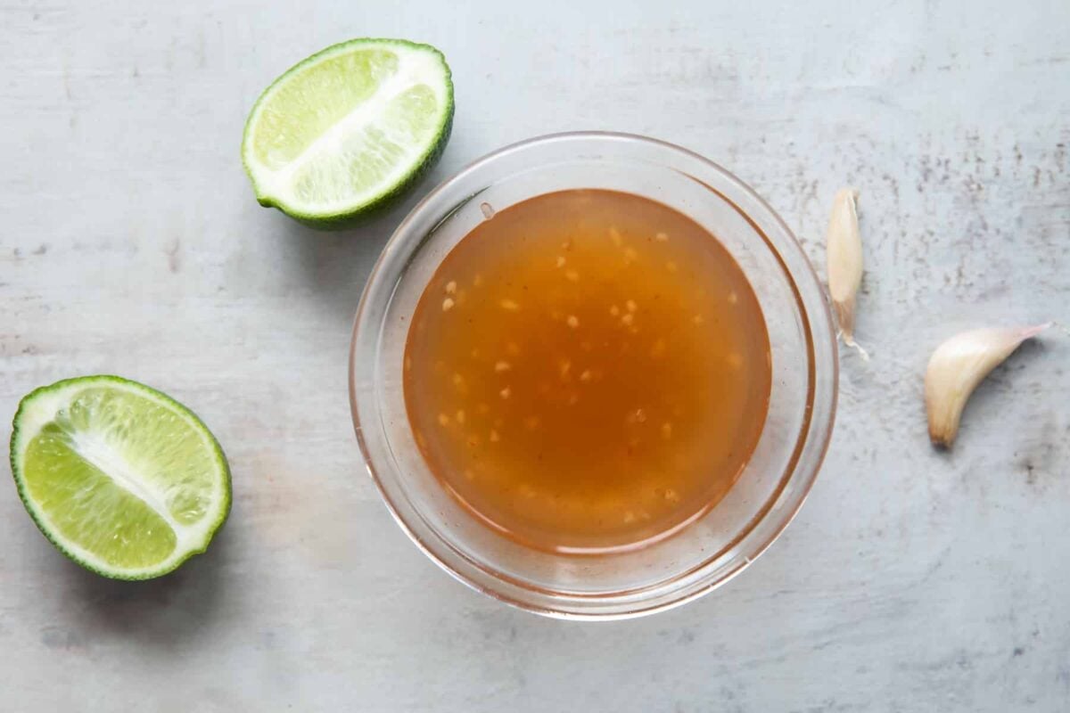 A clear glass bowl of Nuoc Cham.