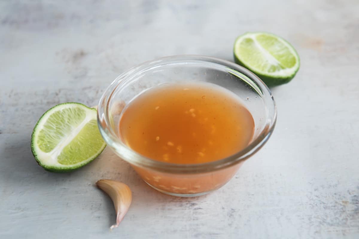 A clear glass bowl of Nuoc Cham.
