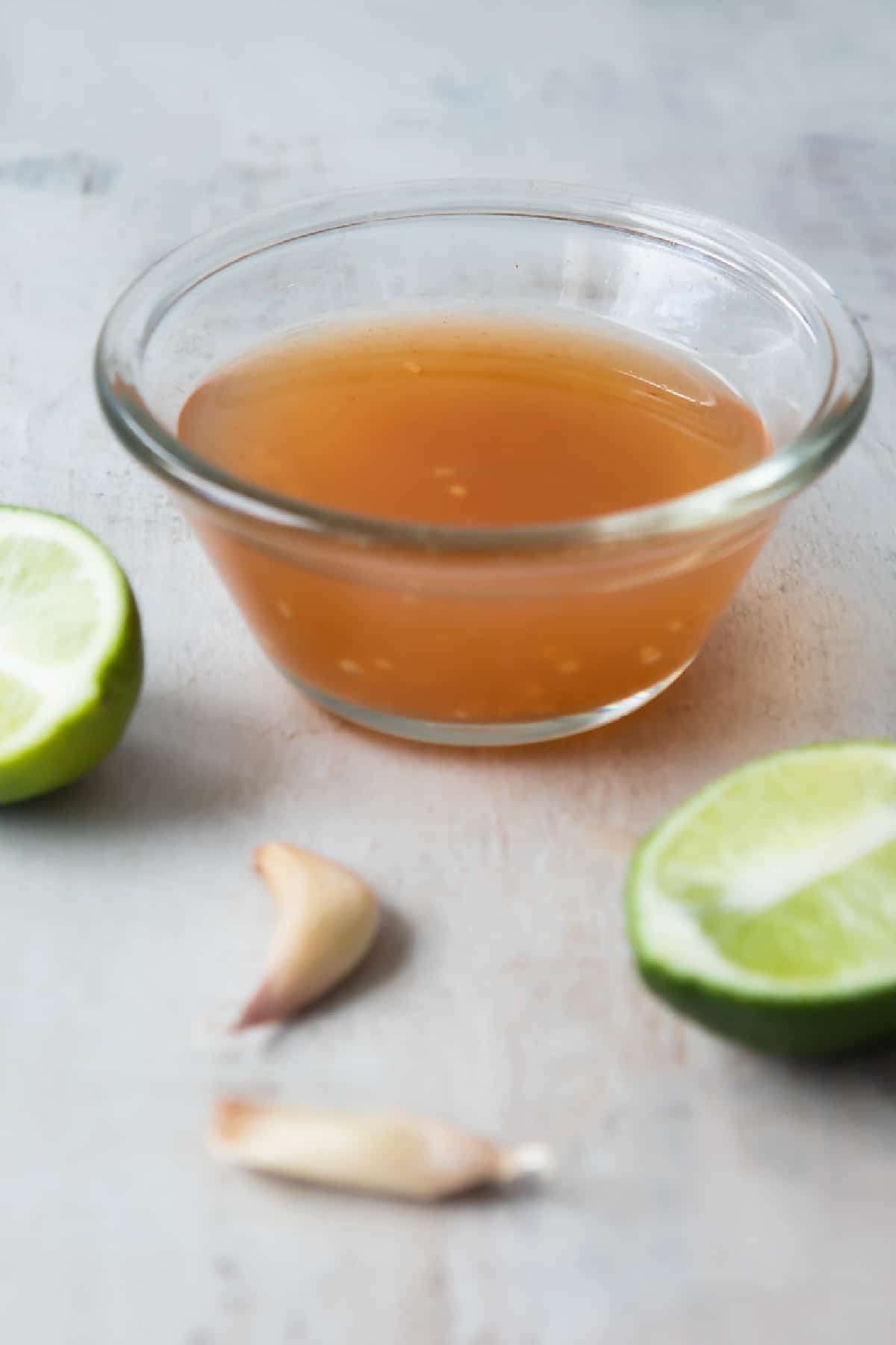 A clear glass bowl of Nuoc Cham.