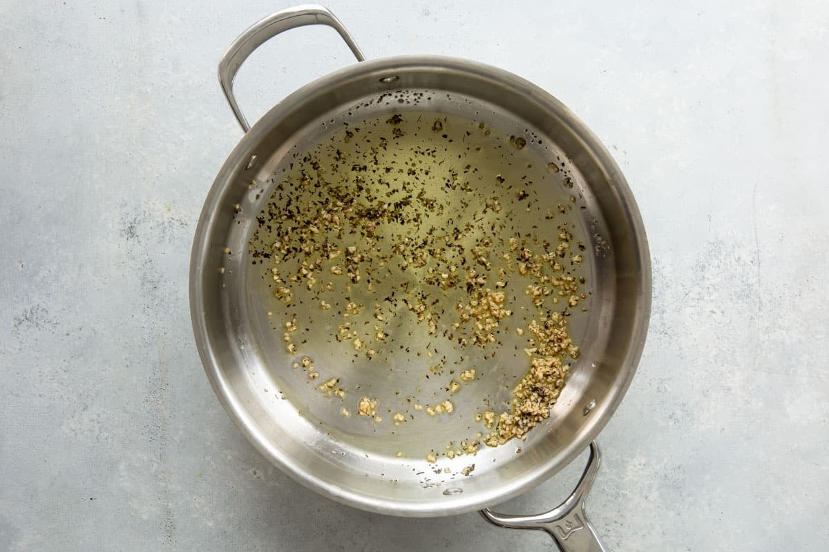 Garlic and spices in a skillet in olive oil.