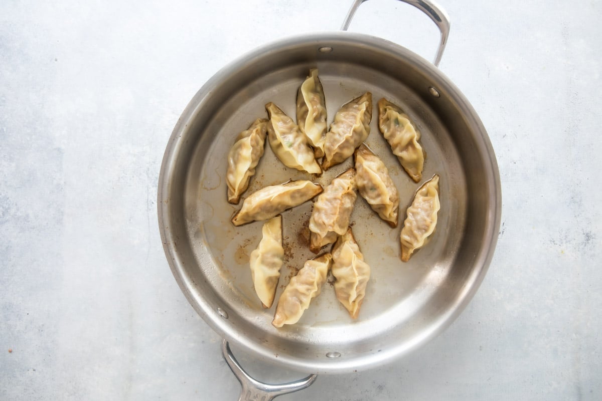 Potstickers in a skillet after browning and steaming.