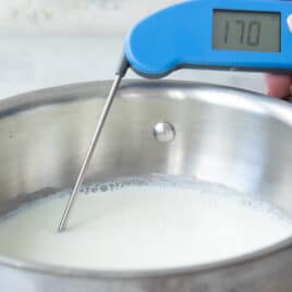 A pot of scalded milk with a thermometer.