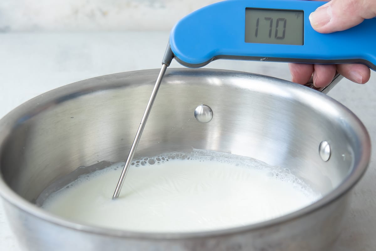 A pot of scalded milk with a thermometer.