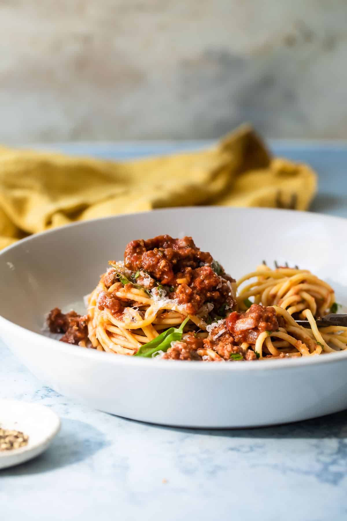 Spaghetti with sauce in a white bowl.