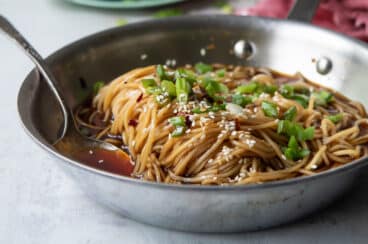 A silver skillet filled with teriyaki noodles.