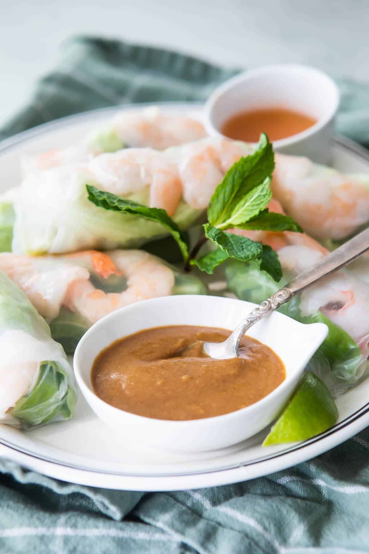 A platter of Vietnamese shrimp rolls with dipping sauces.