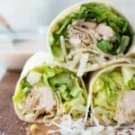 A board full of Chicken Caesar Wraps sliced in half.