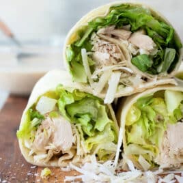 A board full of Chicken Caesar Wraps sliced in half.