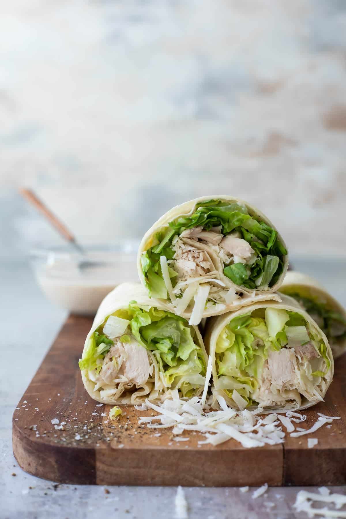 A board full of Chicken Caesar Wraps sliced in half.