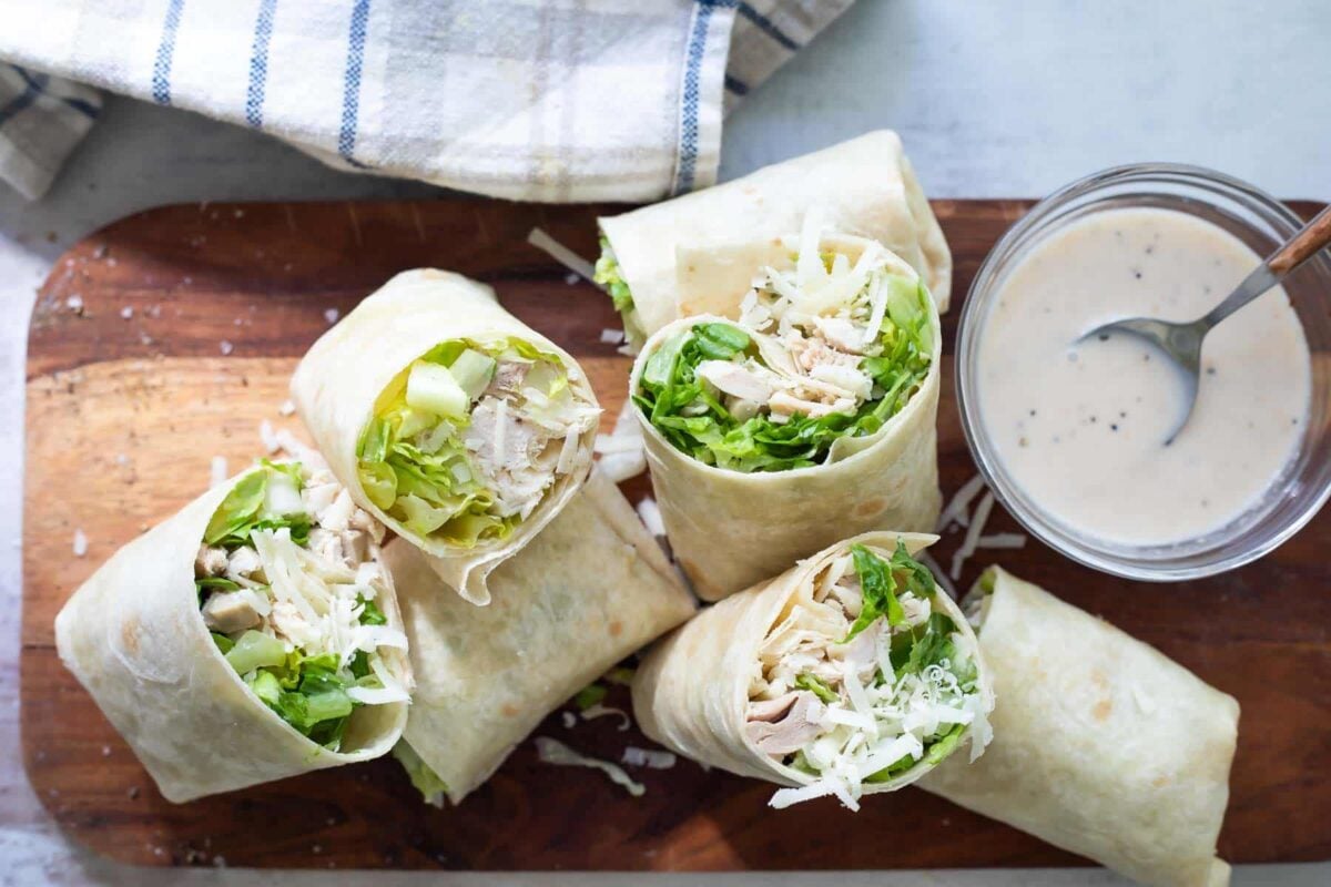 A board full of Chicken Caesar Wraps sliced in half.