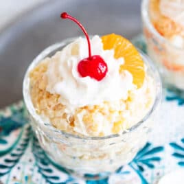 To dishes of frog eye salad with maraschino cherries on top.