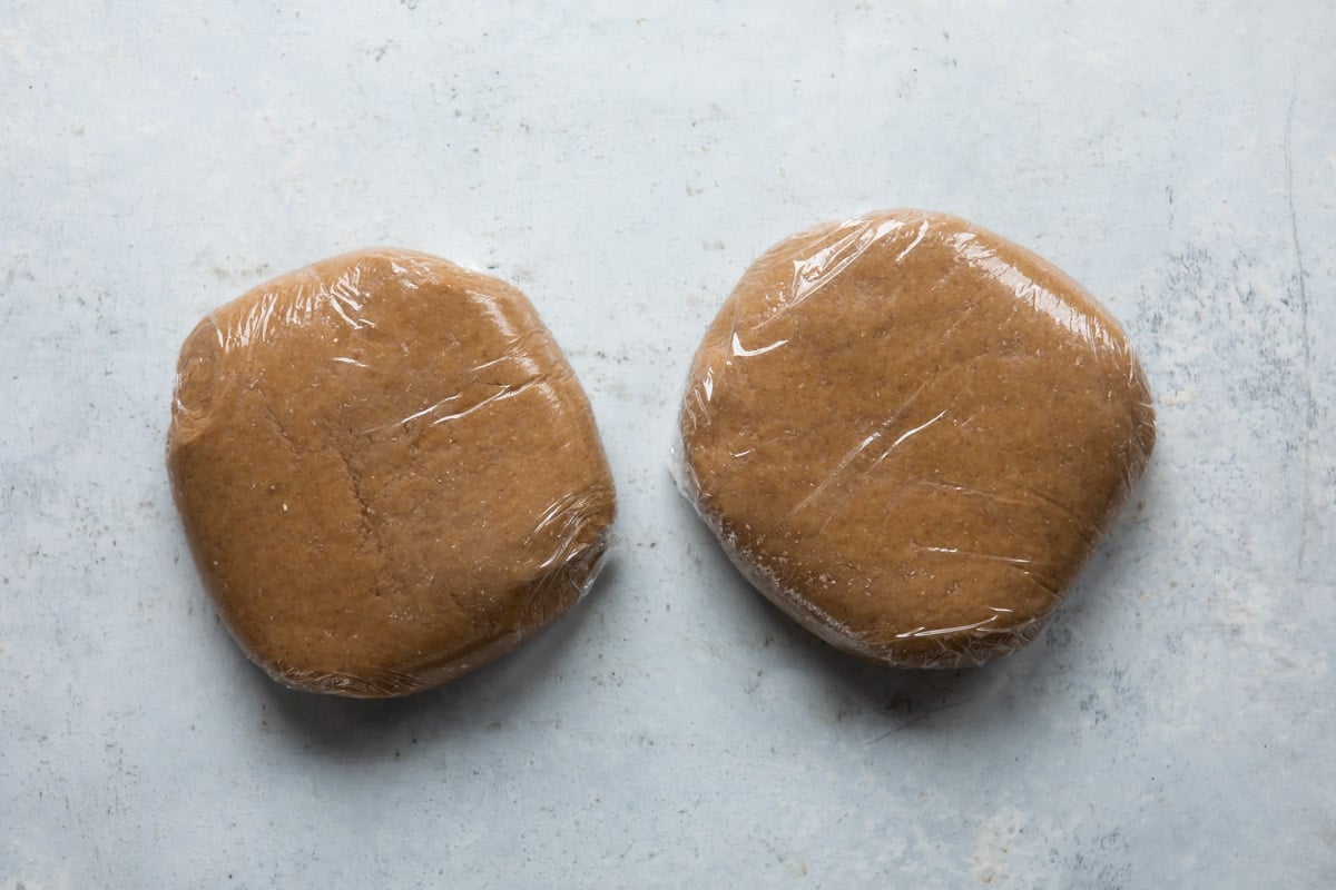 Two blocks of graham cracker dough wrapped in plastic.