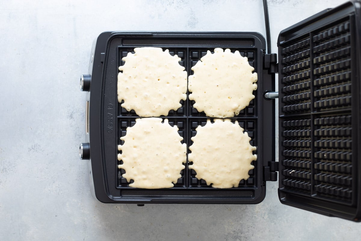 A waffle iron making four waffles.