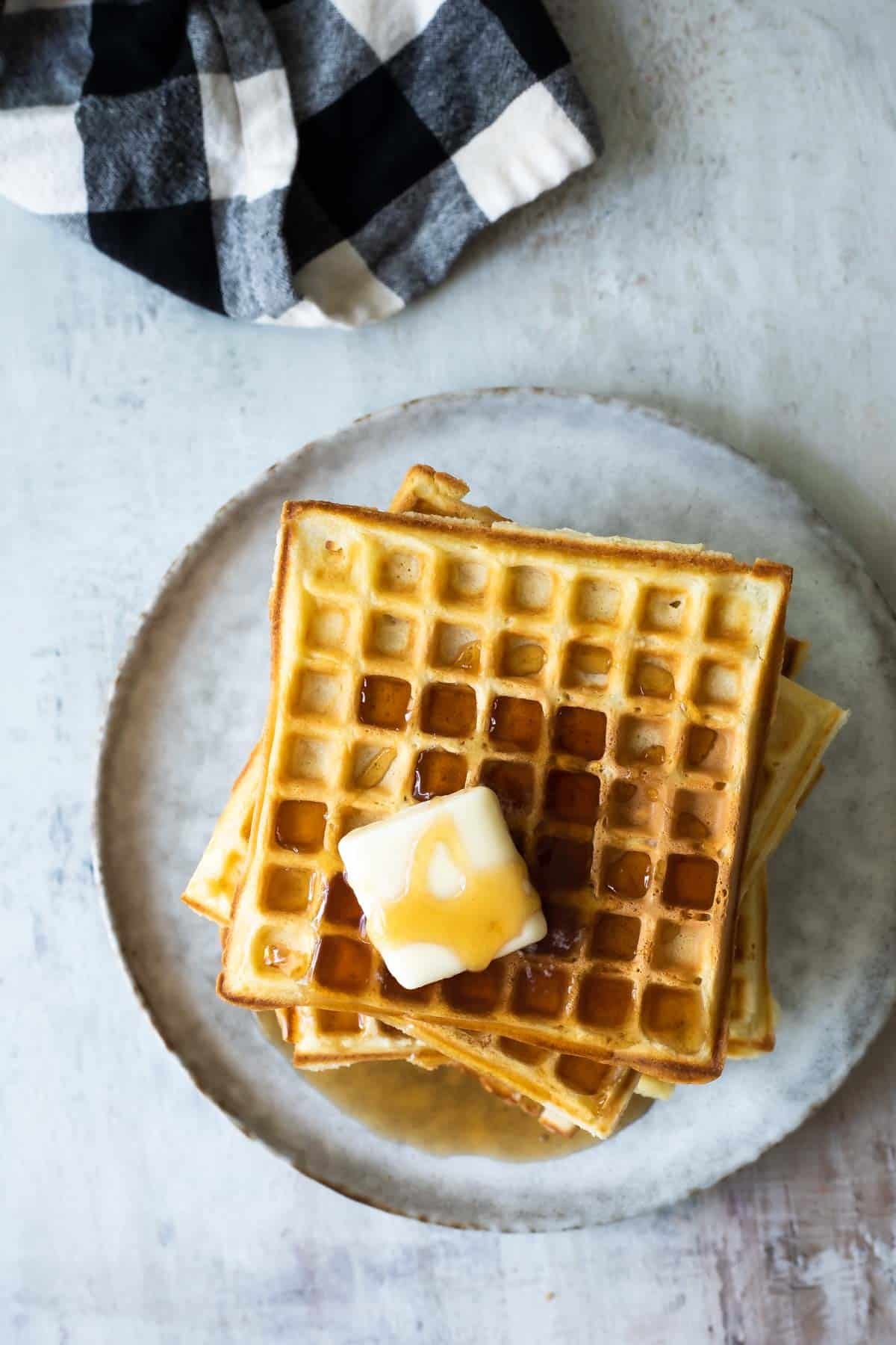 A stack of waffles on a plate.
