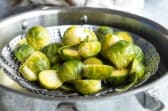Brussels sprouts in a steamer basket.