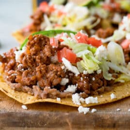 A tostada on a wooden cutting board.