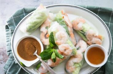 A platter of Vietnamese shrimp rolls with dipping sauces.