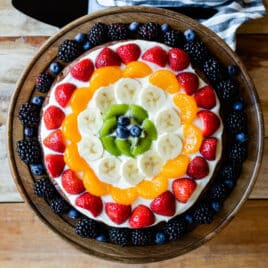 A brownie pizza on a wooden platter.