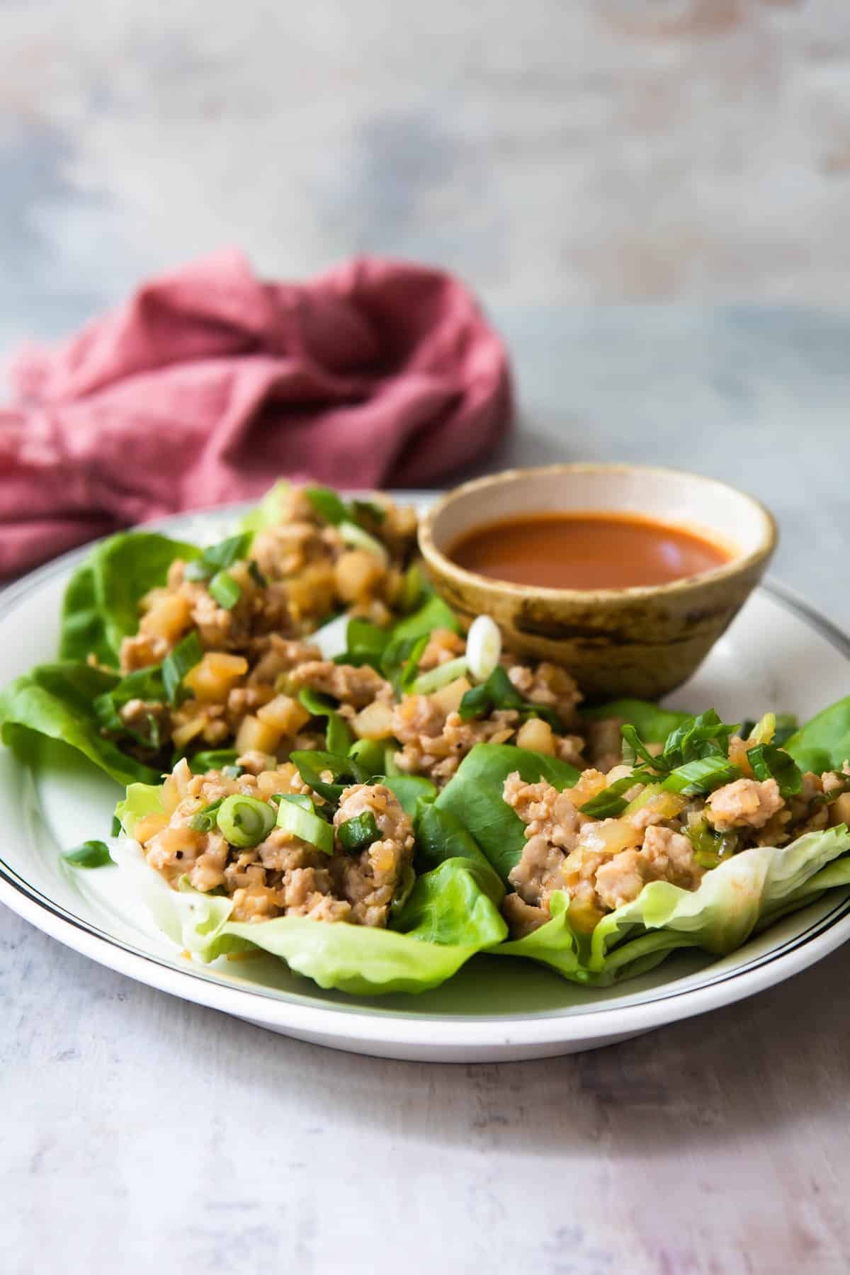 Chicken lettuce cups on a large white serving platter.