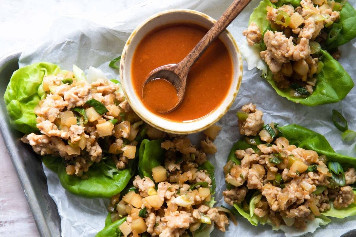 Chicken lettuce cups on a parchment paper lined baking sheet.
