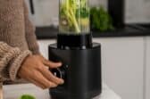 Someone turning on a blender to make a smoothie.
