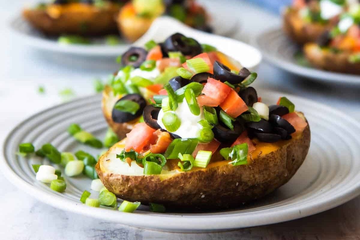 Two baked potato skins on a gray plate.