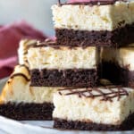 A stack of cheesecake brownies on a platter.