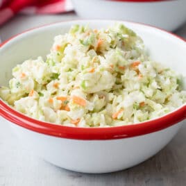 KFC coleslaw in a white bowl with a red rim.