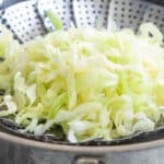 Shredded cabbage in a steamer basket.