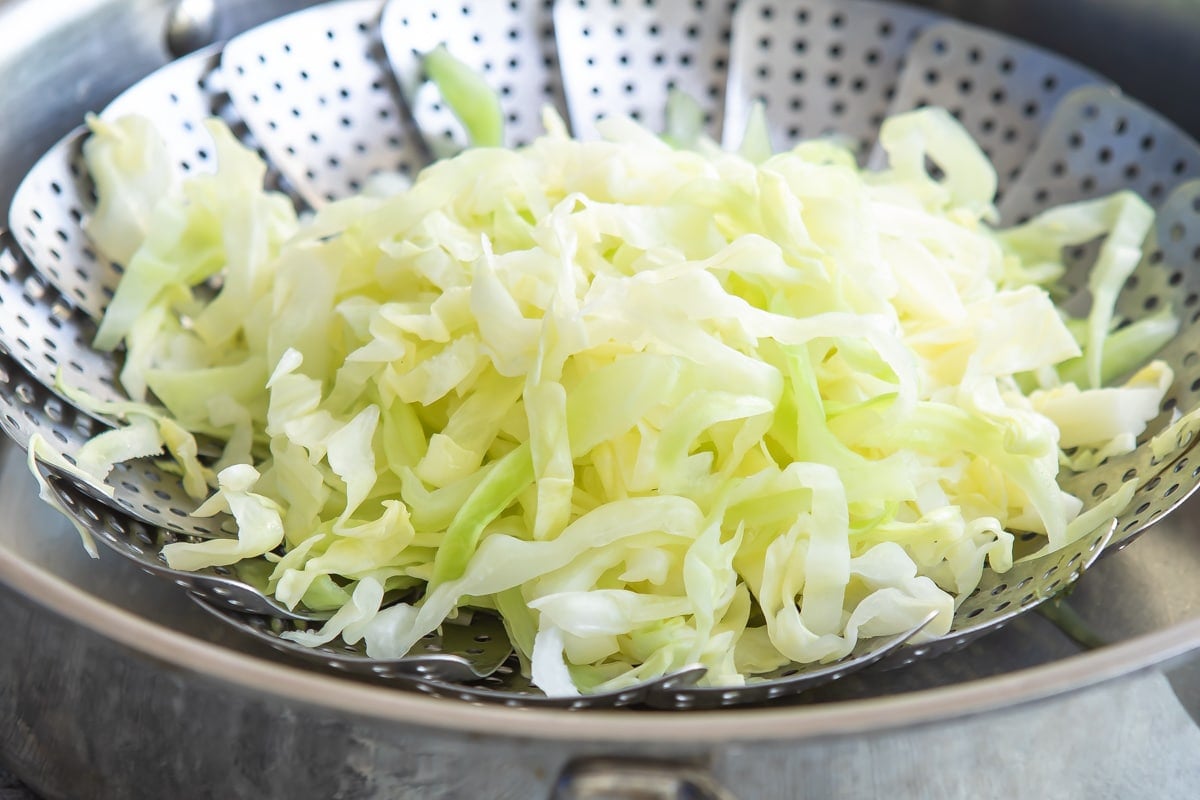 Shredded cabbage in a steamer basket.