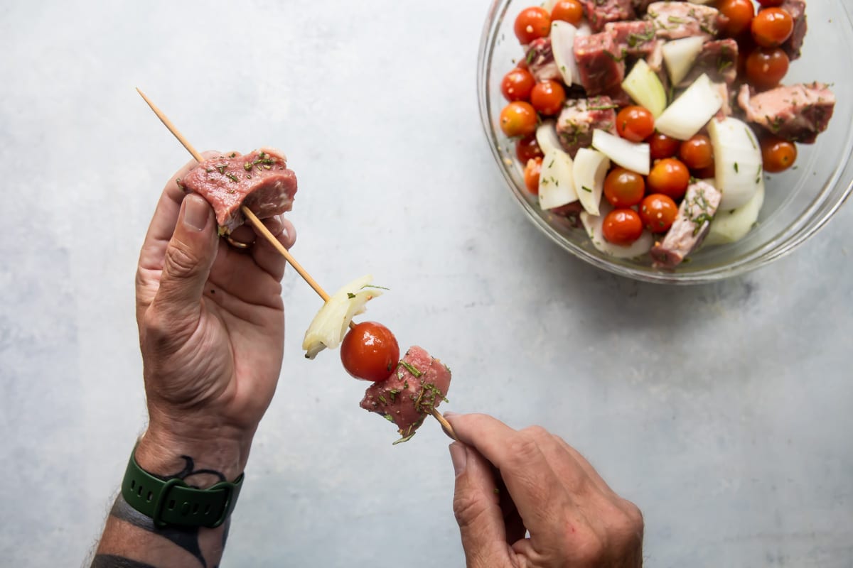 Skewering beef kabobs.