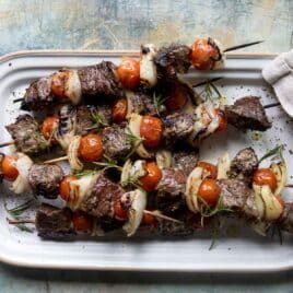 A platter full of beef kabobs.