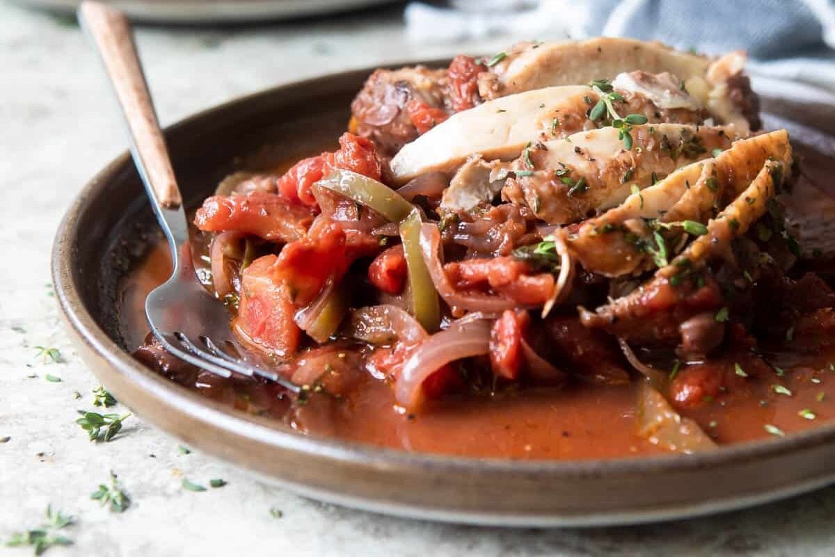 Sliced Chicken Cacciatore on a brown plate.