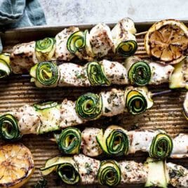 Chicken kabobs on a baking sheet.
