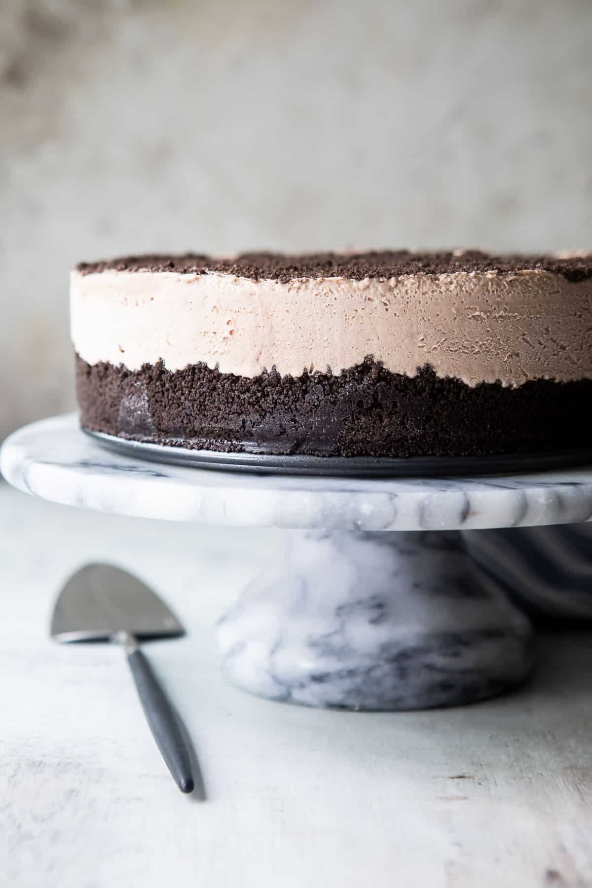 Frosty cheesecake on a marble serving platter.