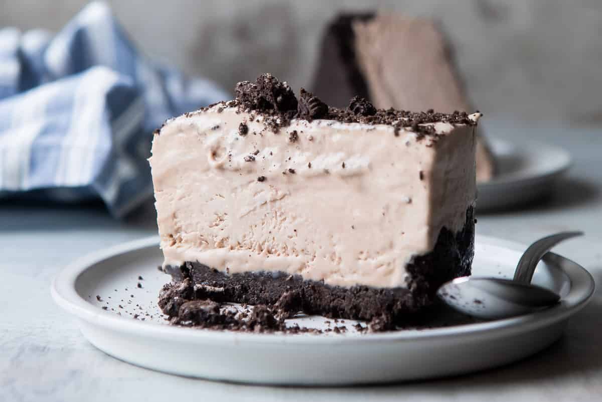 A slice of frosty cheesecake on a small plate.