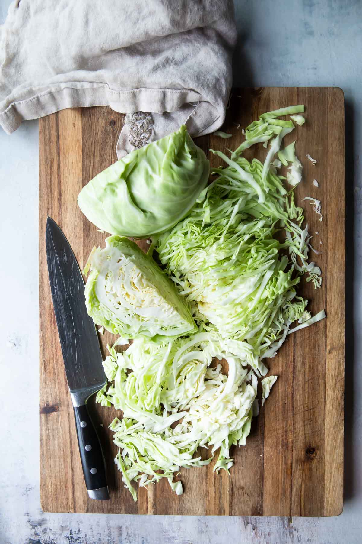 Cut cabbage on a wooden cutting board.